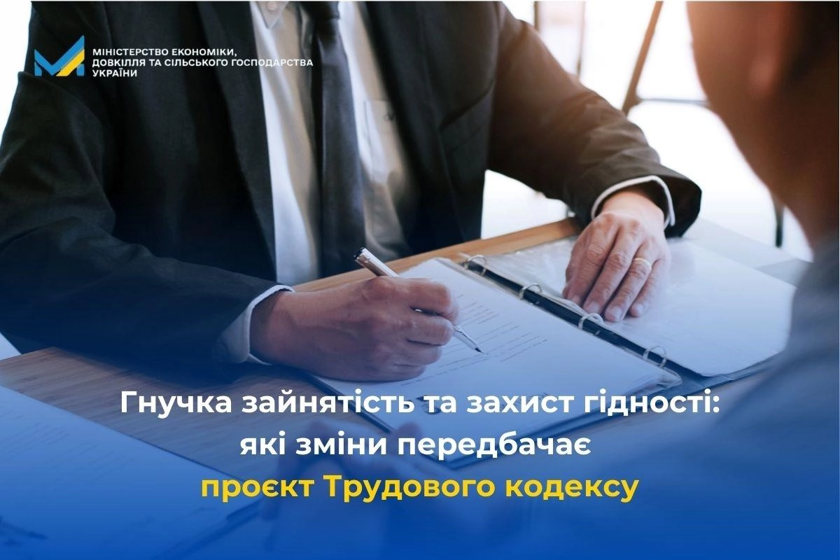 Двоє людей обговорюють документи на робочому столі, присвячені проєкту Трудового кодексу України