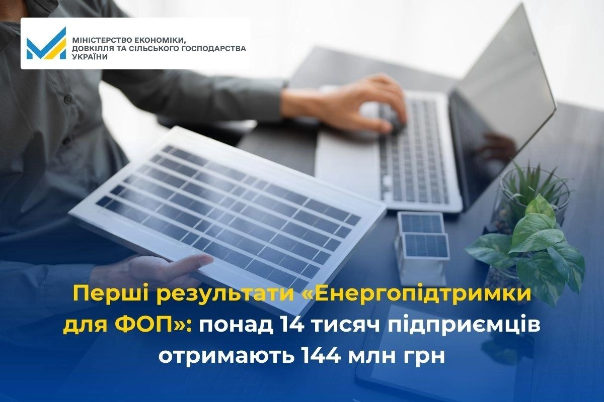 Людина тримає сонячну панель, поруч ноутбук і документи, що символізують енергопідтримку бізнесу